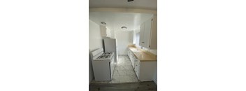 A kitchen with a white fridge, stove and cabinets.