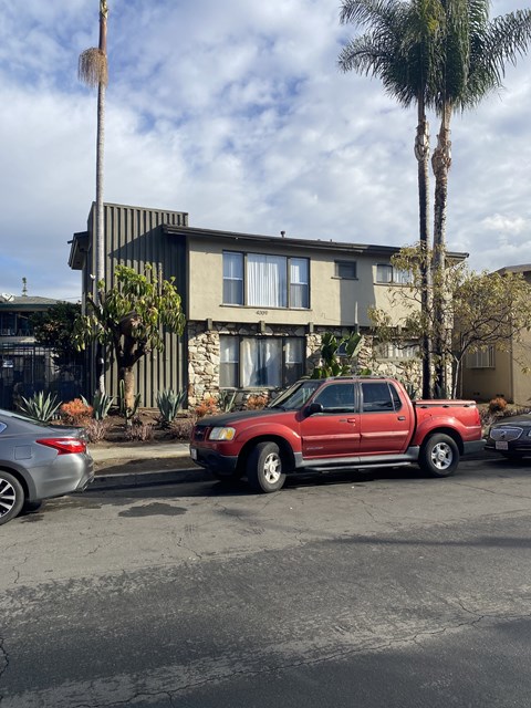 A red pickup truck is parked in front of a house.