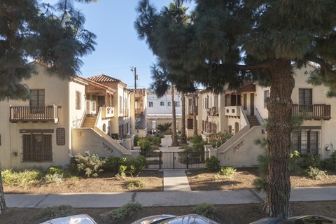 A row of houses with trees in front.