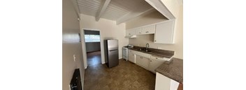 A kitchen with white cabinets and a brown countertop.