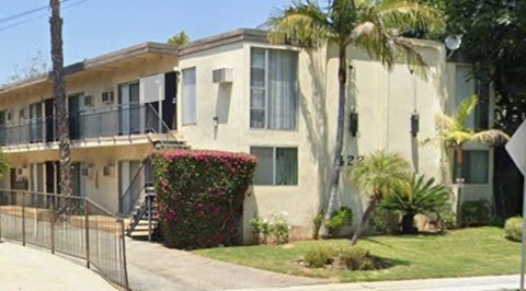 A row of houses with a fence in front.