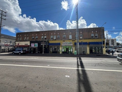 A sunny day in a town with a Cricket store on the corner.