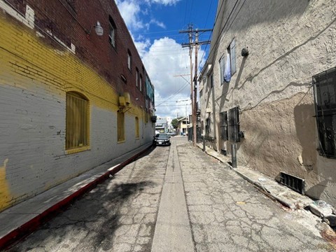 A narrow street between two buildings with a clear sky above.
