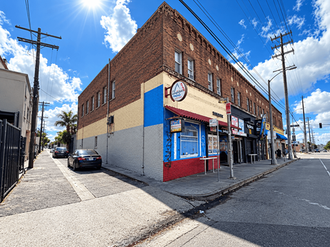 A street view of a building with a clock on the front.