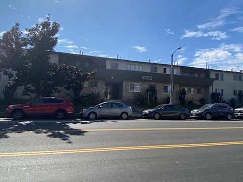 A red car is parked on the left side of the street.
