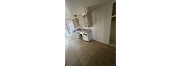 A kitchen with white appliances and cabinets.