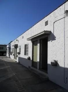 A white building with a green door and windows.