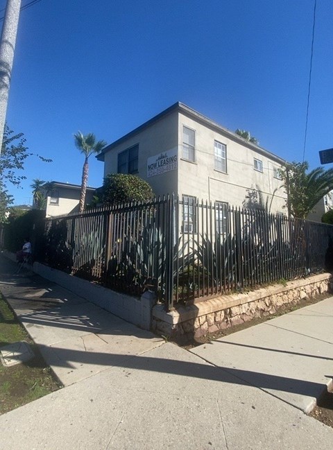 A house with a fence and a sign that says "NO PARKING".