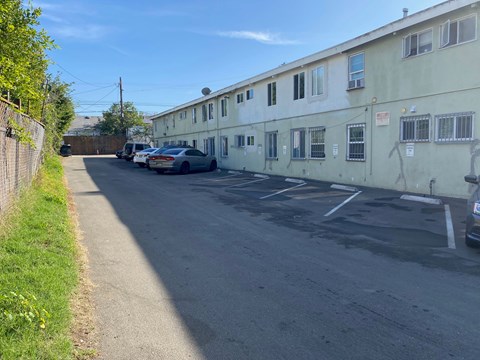 A street view of a residential area with cars parked on the side.