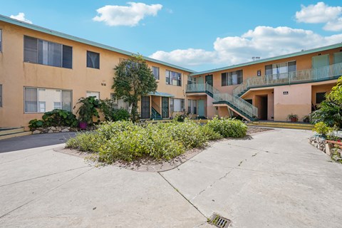 A sunny day at the courtyard of a multi-story apartment building.