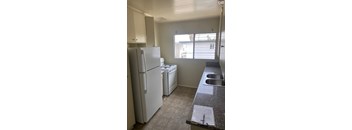 A kitchen with a white fridge, a dishwasher, and a sink.