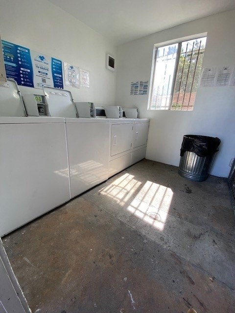 A room with a white counter and a window with a view of a fence and trees.