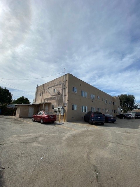 A parking lot with a building and cars.