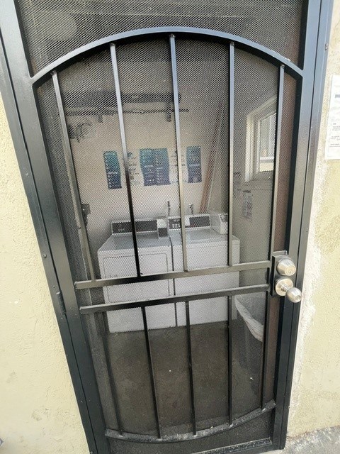 A metal gate with a mesh top is open.
