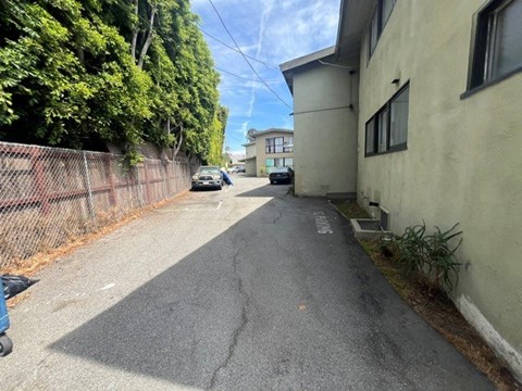 A narrow street with a car parked on the side.