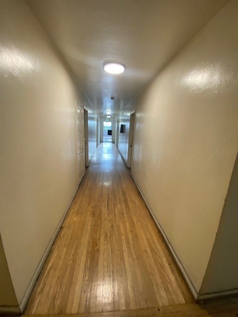 A long hallway with wooden floors and white walls.