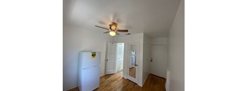 A white fridge in a room with a ceiling fan.