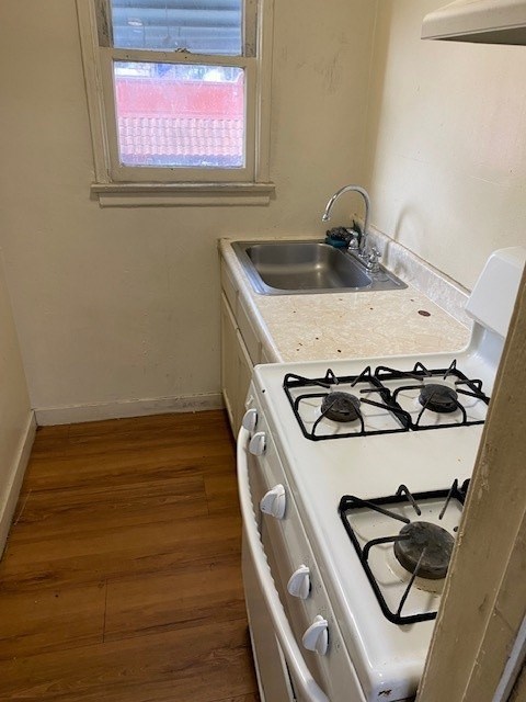 A white gas stove with a sink in the corner.