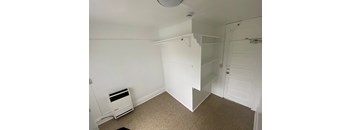 A room with a white door and a white shelf.