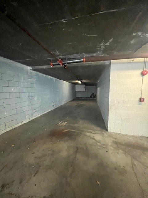 A long concrete tunnel with a red fire extinguisher on the right side.