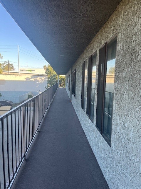 A balcony with a metal railing and a concrete wall.