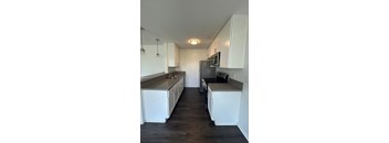 A kitchen with white cabinets and a black countertop.