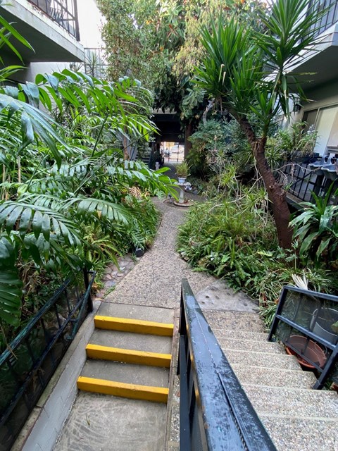 A staircase with yellow handrails leads up to a building.
