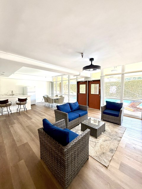 A living room with a blue couch and a glass door.