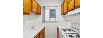 A kitchen with a white stove and wooden cabinets.