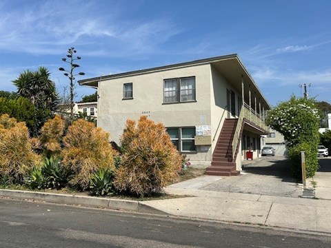 A house with a grey facade and a red door.