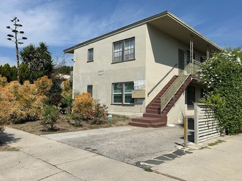 A house with a beige facade and a red staircase.