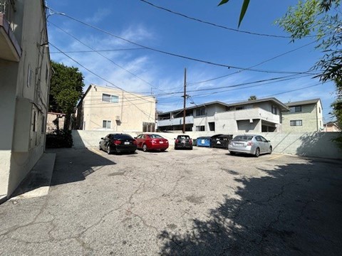 A parking lot with several cars parked in front of a building.