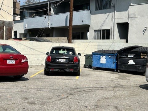 A black car is parked in a parking lot.