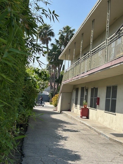 A building with a balcony and a red object on the ground.