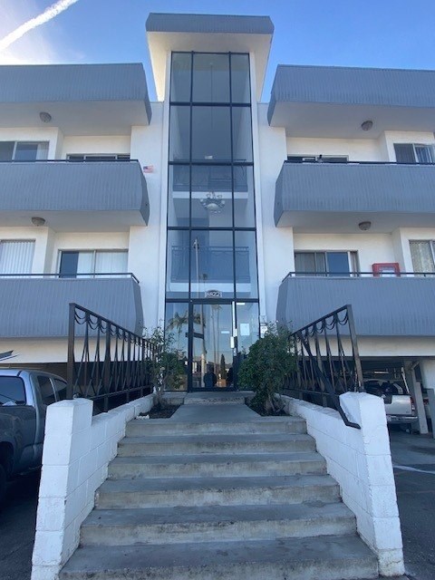 A modern building with a glass entrance and white walls.