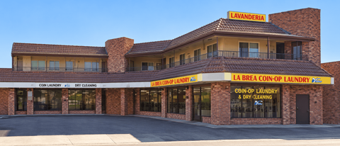 A laundromat named Lavanderia with a sign that says "coin laundry" and "dry cleaning.".