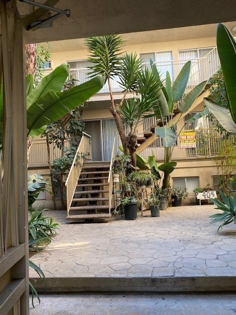 A courtyard with a staircase and a tree.
