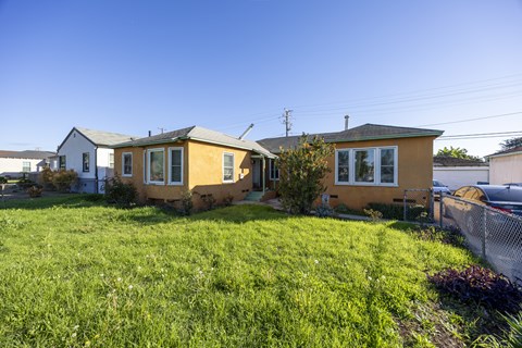 Two houses with a green lawn in front.