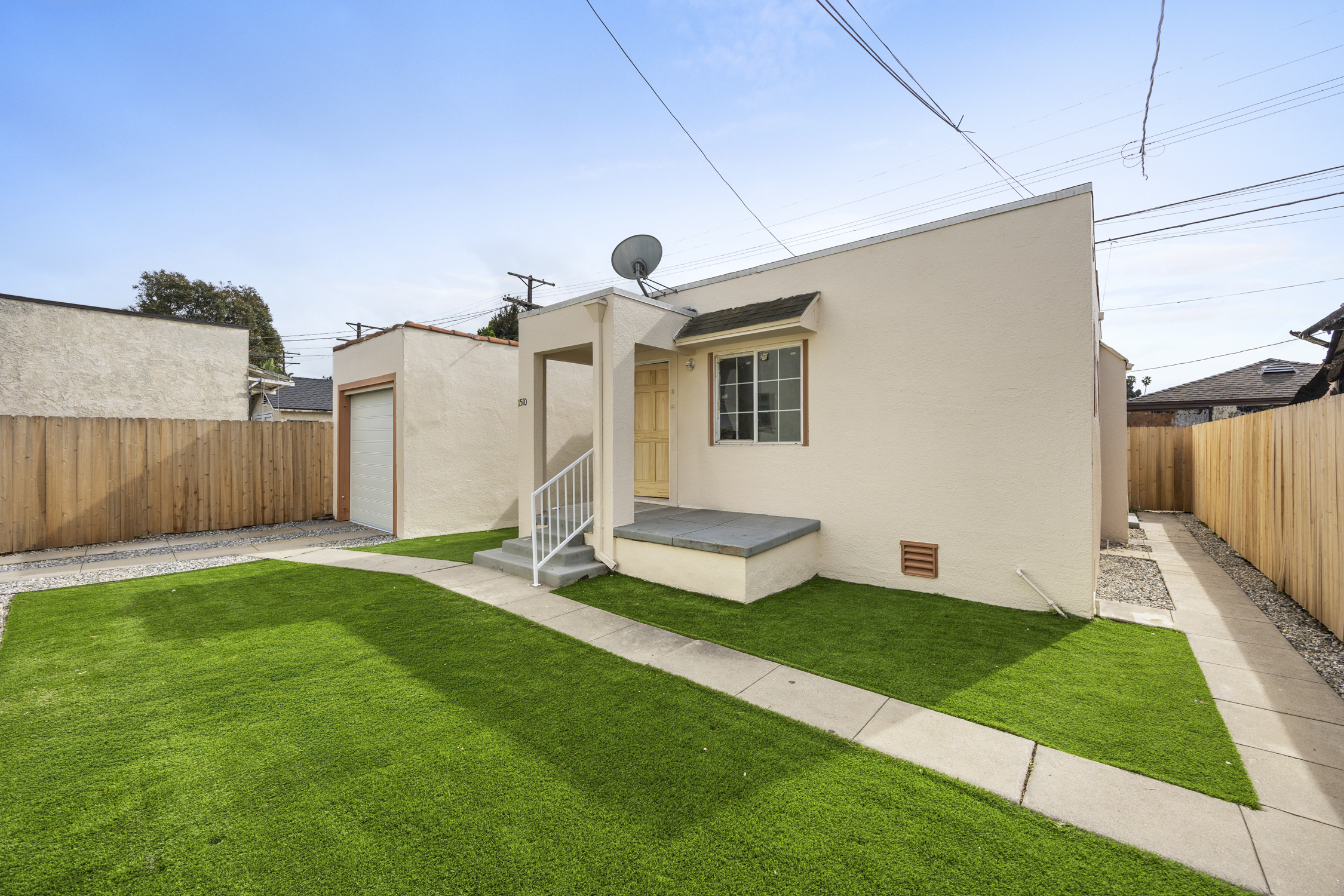 A small house with a green lawn in front.