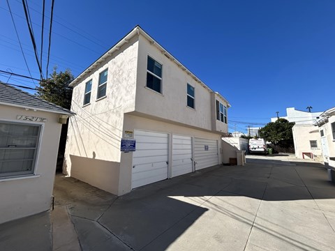 A two-story house with a garage is situated in a sunny area.
