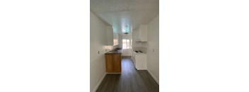 A kitchen with white cabinets and a wooden island.