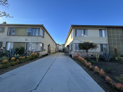 A long concrete pathway leads between two rows of identical buildings.