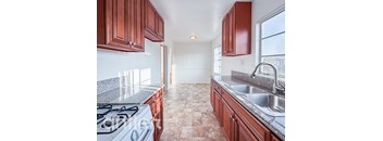 A kitchen with a white stove and brown cabinets.