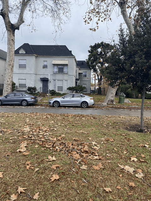 Two cars parked in front of a house.