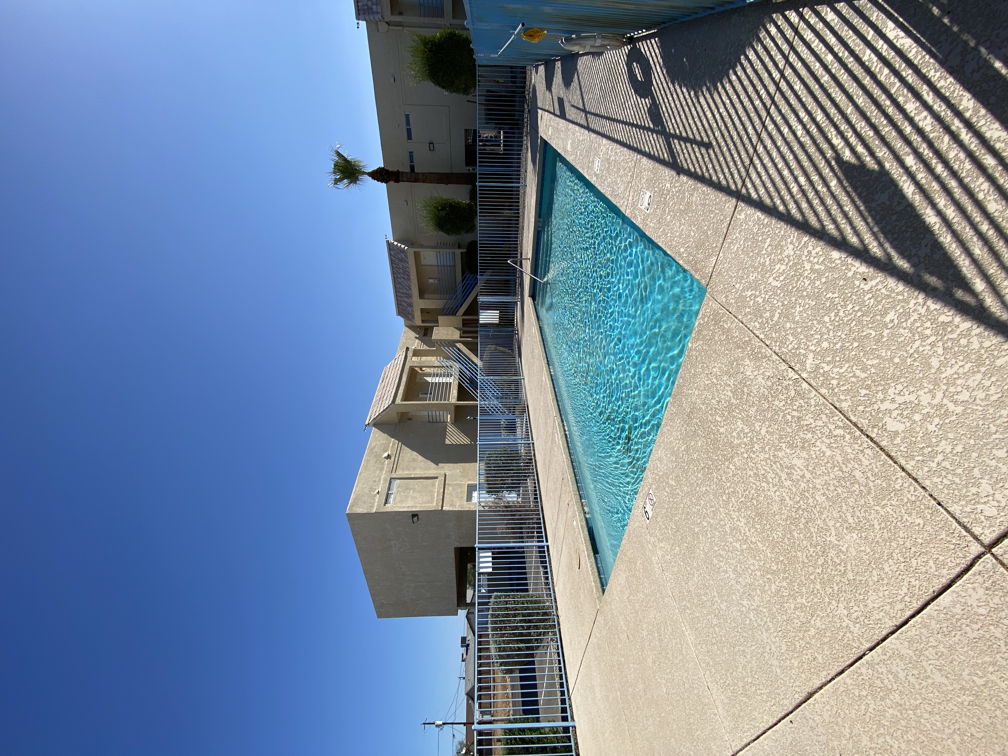 A tall building with a pool on the side.