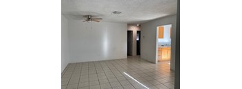 A room with a ceiling fan and tiled flooring.