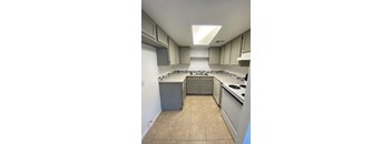A kitchen with white appliances and beige cabinets.