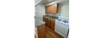 A white gas stove is in a kitchen with wooden cabinets.
