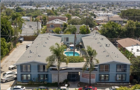 A large blue house with a pool in the middle of a parking lot.