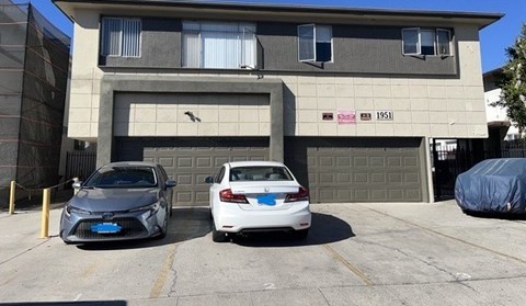 Two cars are parked in front of a garage door.
